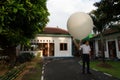 BADUNG/BALI-APRIL 10 2019: An observer at Ngurah Rai Meteorological station releasing the big white radio sonde balloon to measure