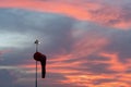BADUNG/BALI-APRIL 14 2019: Wind sock under at the dawn under the red orange glowing sky with cirrus and cumulus clouds