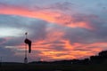 BADUNG/BALI-APRIL 14 2019: Wind sock under at the dawn under the red orange glowing sky with cirrus and cumulus clouds