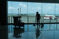 BADUNG/BALI-MARCH 28 2019: the silhouette of a janitor is cleaning the departure terminal floor with airplane background and airpo