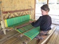 BADUY VILLAGE/INDONESIA - SEPTEMBER 27, 2014: Baduy women weaving traditional cloth using vintage loom