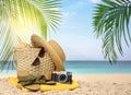 Bag with accessories and vintage camera on sunny ocean beach, space for text. Summer vacation Royalty Free Stock Photo