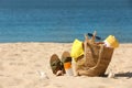 Bag with beach accessories and slippers on seaside. Space for text Royalty Free Stock Photo