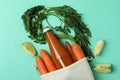Bag with bottle of apple - carrot juice and ingredients on mint background