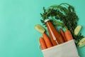 Bag with bottle of apple - carrot juice and ingredients on mint background