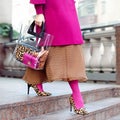 Bag close-up in female hands. Stylish modern and feminine image, style. Girl in pink tights