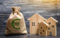 A bag with euro money and three houses. Affordable cheap loan, mortgage. Taxes, rental income. Building houses. Municipal budget Royalty Free Stock Photo