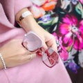 Bag in female hands closeup. Sunglasses in the hands woman. Fashion ladies accessories, bracelets, eyeglasses.