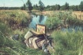 Bag with fishing essentials at riverside on sunny day Royalty Free Stock Photo