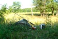 Bag with fishing essentials at riverside on sunny day Royalty Free Stock Photo