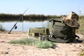 Bag with fishing essentials at riverside Royalty Free Stock Photo