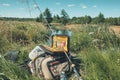 Bag with fishing essentials at riverside on sunny day Royalty Free Stock Photo