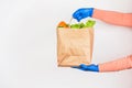 A bag of food in the hands of gloved hands on a white background.