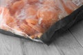 Bag of frozen sliced carrots on a wooden worktop