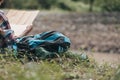 Bag on the ground and Lost hiker with backpack checks map to find directions near the river in the forest. hiking and adventure Royalty Free Stock Photo