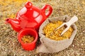 Bag with healing herbs and red tea kettle Royalty Free Stock Photo