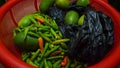 A bag of lemon with green, red chili in a red basket on a wooden board. Royalty Free Stock Photo