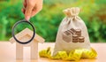 Bag with money and tape measure with a wooden house. Market crisis. The concept of a limited real estate budget. Low subsidies. Royalty Free Stock Photo