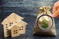A bag with money and wooden houses. Selling a house. Apartment purchase. Real estate market. Rental housing for rent. Home prices Royalty Free Stock Photo