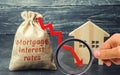 Bag with the money and the word Mortgage interest rates and arrow to down and house. Low interest in mortgages. Reducing interest Royalty Free Stock Photo