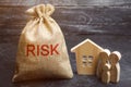 A bag with money and the word risk and a wooden house. Buying property on credit. The concept of financial risk. Loss of housing