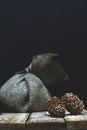 A bag of natural matting on a wooden table on a dark background and cedar cones, a copy space for your text