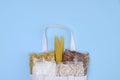 A bag with packages of oat and buckwheat, sugar and pasta lies on a blue background. Food delivery concept. Copy space