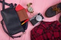 bag, passport, camera, compass, shoes, shirt, note pad on pink wooden background