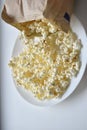 A bag of popcorn open on a plate in the kitchen Royalty Free Stock Photo