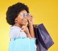 Bag, portrait and black woman shopping, excited and celebrating sale in studio on yellow background. Face, shopper and Royalty Free Stock Photo