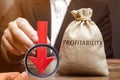 Bag with the word Profitability and a down arrow with a businessman. Low economic efficiency and profitableness. Drop in profits Royalty Free Stock Photo