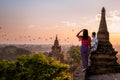 Bagan Myanmar, couple of men and woman looking at the sunrise on top of an old pagoda temple