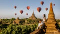 Bagan Myanmar, couple of men and woman looking at the sunrise on top of an old pagoda temple