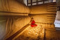 BAGAN, MYANMAR - FEB 20, 2015: Southeast Asian young little Buddhist monks praying with candle light in a Buddihist temple on FEB