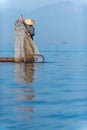 Burmese fisherman dressed in traditional style standing at the back of the boat Preparing fishing equipment