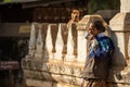 Bagan / Myanmar - Jan 12, 2014: Burmese woman leaning against the temple wall, drinking tea in the morning