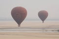 Bagan, Myanmar - March 2019: hot air balloons landing near Irrawaddy river