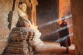 BAGAN, MYANMAR - May 2016: Monk burning candles in front of Buddha statue inside pagoda on May, 2016 in Bagan.