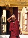 BAGAN, MYANMAR - NOV 13, 2015: Ethnic monk portrait. Young Asian man in robe of monk standing in front of temple entrance.