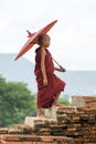 Bagan, Myanmar - A Novice Monk with Red Umbrella Climbs Ancient Temple