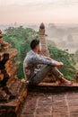 Bagan Myanmar young men watching Sunrise from the roof top of an ancient temple, man sunset roof pagoda temple Bagan