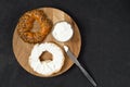 Bagel and cream cheese as a concept for breakfast. Wooden tray, black background