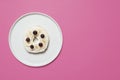 Bagel on a plate on a pink background
