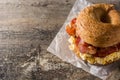 Bagel sandwich with bacon, egg and cheese on wooden table. Royalty Free Stock Photo