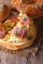 Bagel with scrambled eggs and bacon close-up vertical