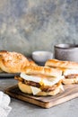 Bagels with fried meat, poached egg and cheese on a board. Homemade fast food. Vertical view Royalty Free Stock Photo