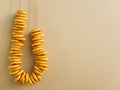 Bagels hang on a string on the yellow wall. Place to add text