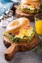 Bagels with scrambled eggs, rucola and fried bacon Royalty Free Stock Photo