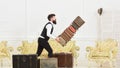 Baggage insurance concept. Man with beard and mustache in classic suit delivers luggage, luxury white interior Royalty Free Stock Photo