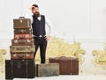 Baggage and relocation concept. Man with beard and mustache packed luggage, white interior background. Macho elegant on